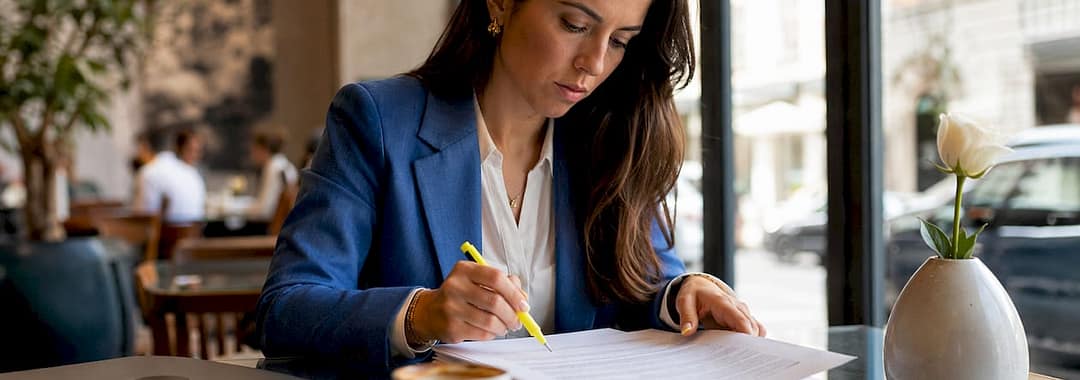 Businesswoman reviewing employment contracts at desk