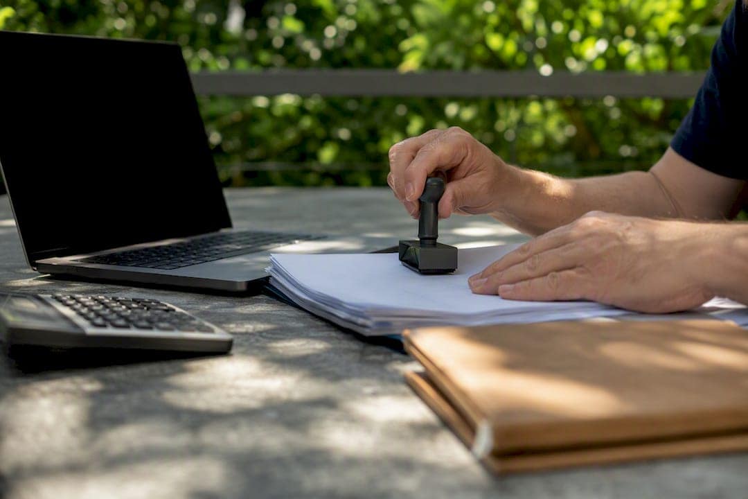 Hands stamping payroll documents on office desk